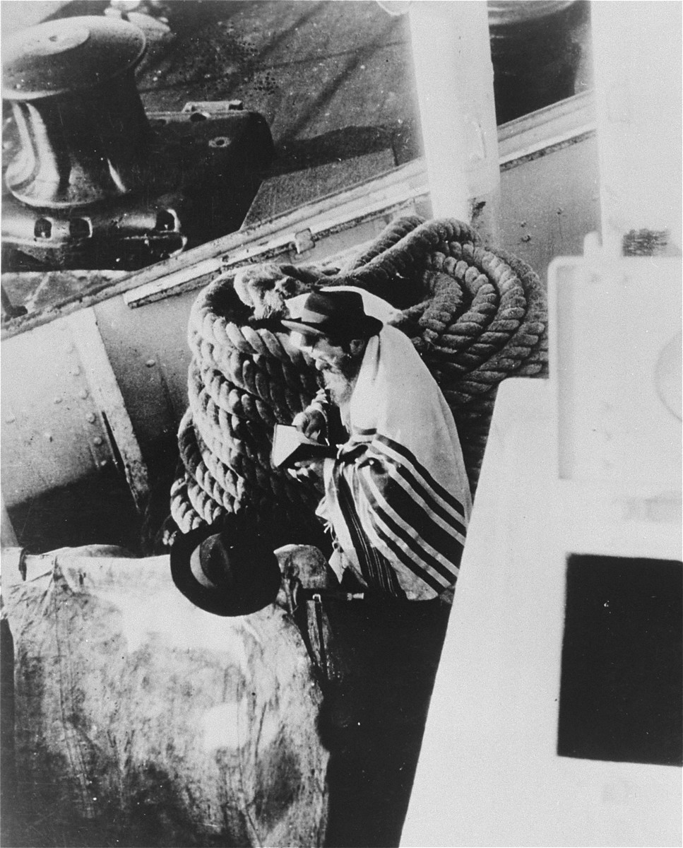 A Jewish passenger prays on board a refugee ship from Germany bound for Argentina in 1938.