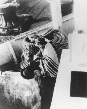 A Jewish passenger prays on board a refugee ship from Germany bound for Argentina in 1938. [LCID: 86618]