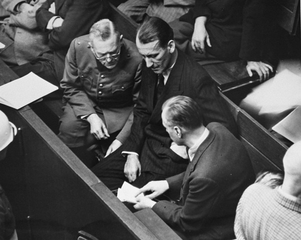 Defendants Wilhelm Keitel (left), Ernst Kaltenbrunner (middle), and Alfred Rosenberg (right), talk during a recess in the proceedings ... [LCID: 10397]