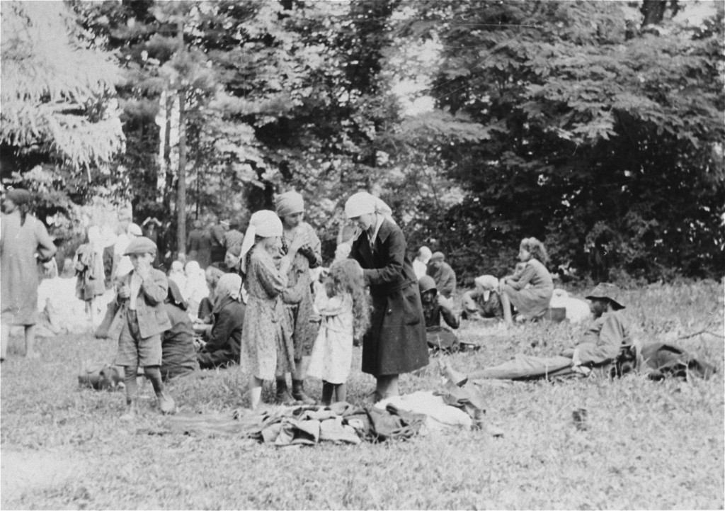 Jews who were expelled from Romania to Hungary eat in an open field. [LCID: 68678a]