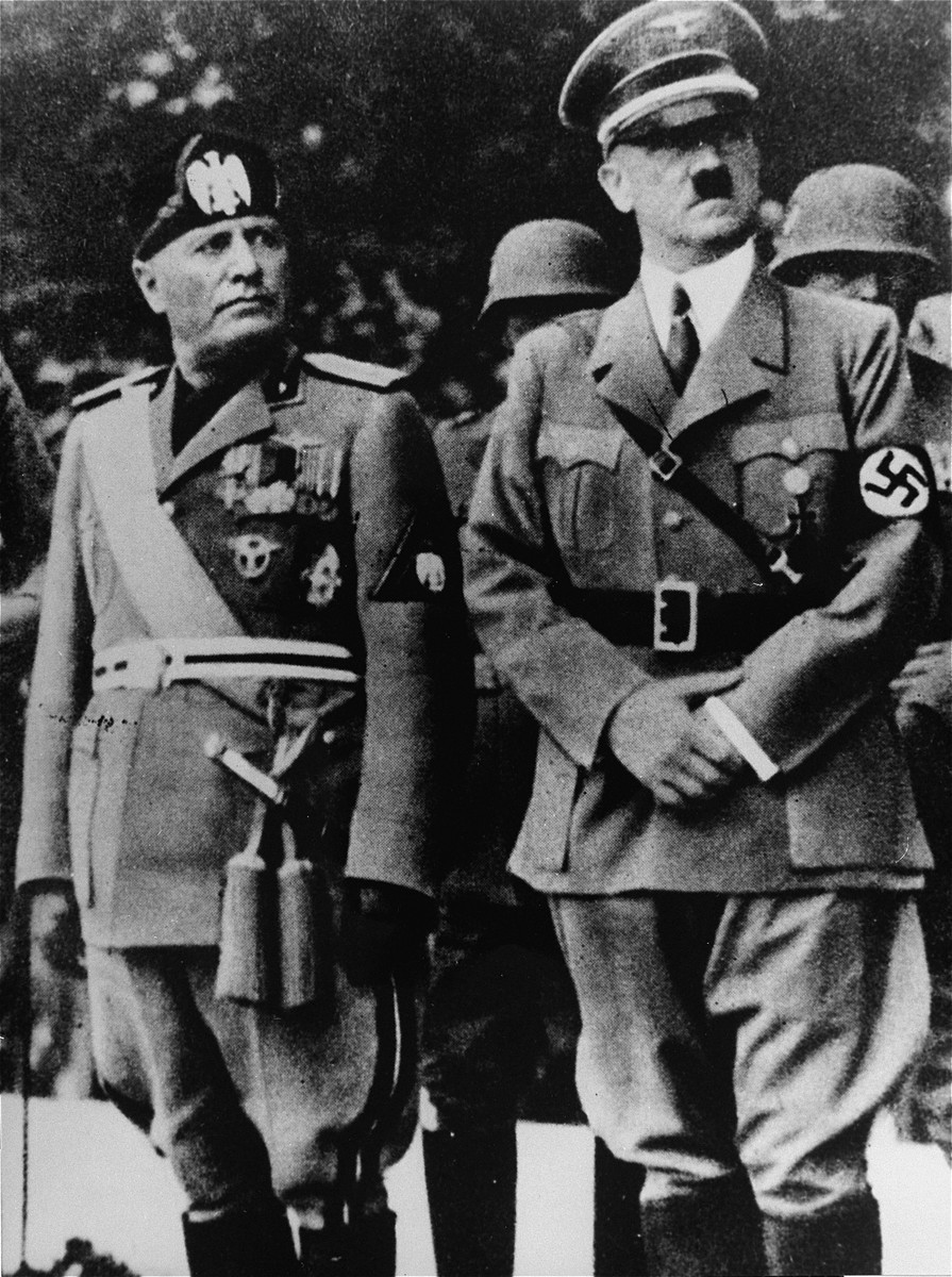 Benito Mussolini and Adolf Hitler stand together on an reviewing stand during a official visit to occupied Yugoslavia, 1941-1943.