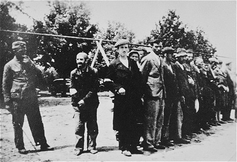  A German soldier with Jews lined up for forced labor. [LCID: 63423]