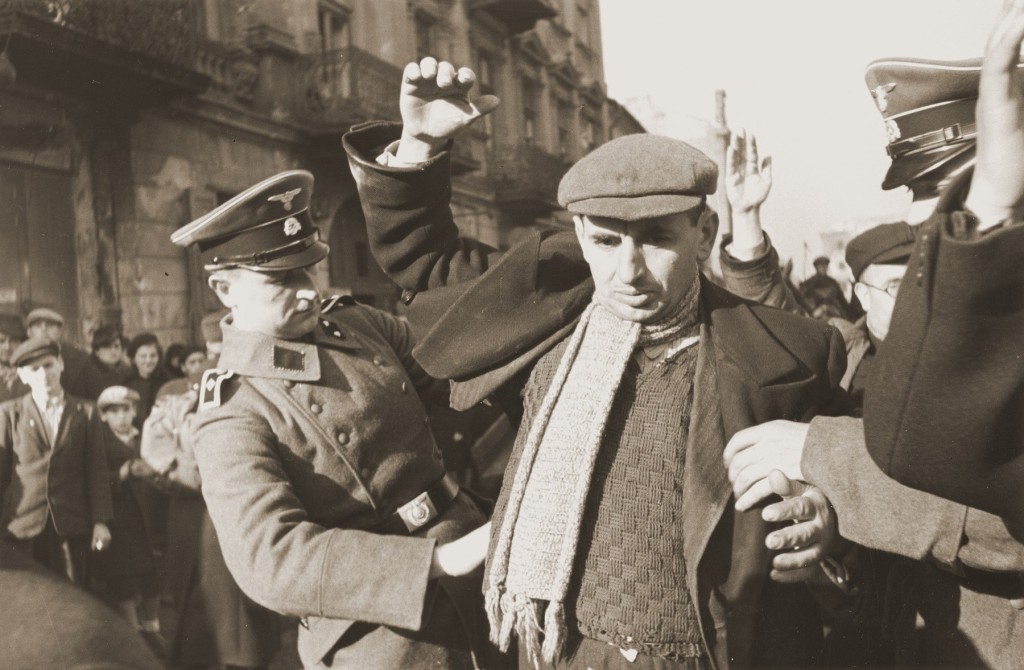 SS men search Jews for weapons. Warsaw, Poland, October or November 1939. [LCID: 46185a]