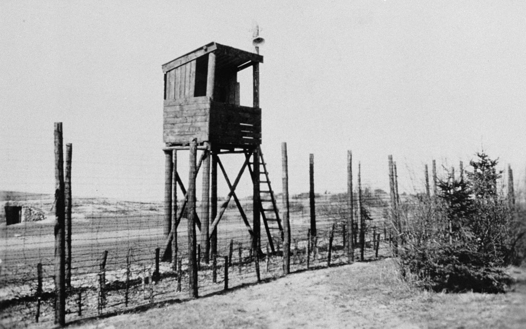A view of one of the watchtowers and part of the perimeter fence at Orhdruf, part of the Buchenwald camp system, seen here after ... [LCID: 76502]