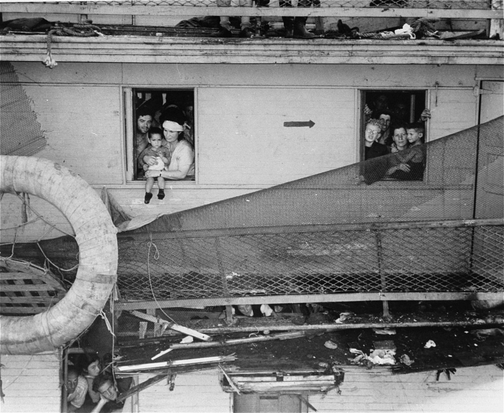 Passengers on board the "Exodus 1947" refugee ship, which has just arrived at the Haifa, Palestine port, peer out of cabin windows.