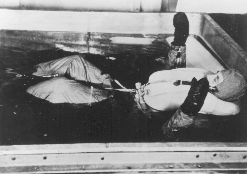 Une victime des expériences médicales nazies est plongée dans de l’eau glacée au camp de concentration de Dachau. [LCID: 29122]