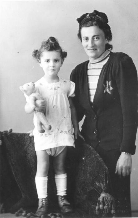 Helena Husserlova, wearing a Jewish badge, poses with her daughter Zdenka (holding a teddy bear) shortly before they were deported to Theresienstadt