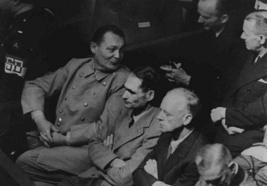Herman Goering se da vuelta para hablar con Karl Doenitz durante el juicio de Nuremberg. [LCID: 08524]