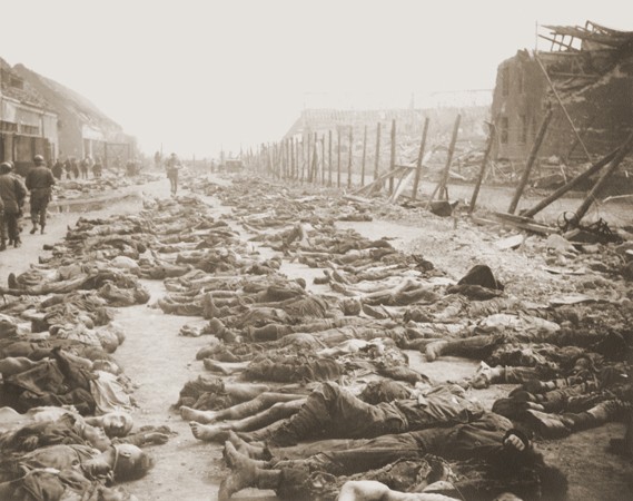 View of the main street of the Nordhausen concentration camp, outside of the central barracks (Boelke Kaserne), where the bodies of prisoners have been laid out in long rows.