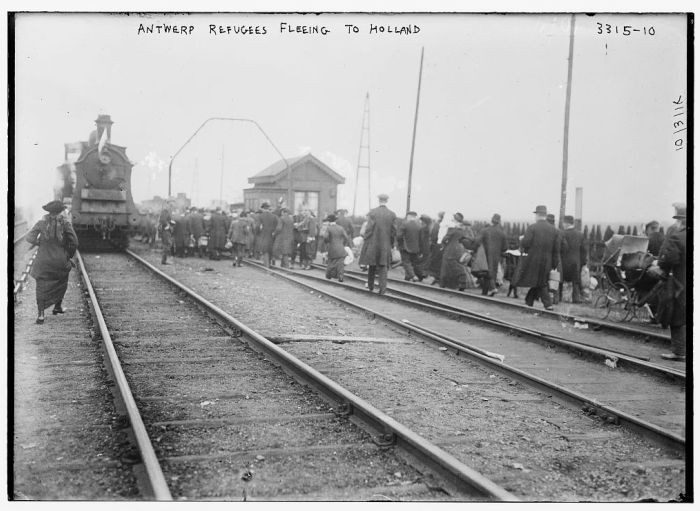 Refugees from Antwerp, Belgium, walk along railroad tracks as they flee to the Netherlands during World War I.