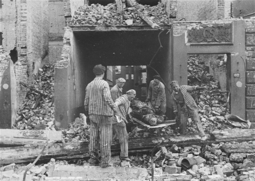 Concentration camp prisoners, many from satellite camps of Neuengamme, remove corpses of German civilians after Allied bombings of ...