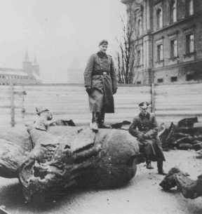  A German soldier stands on a toppled Polish monument.