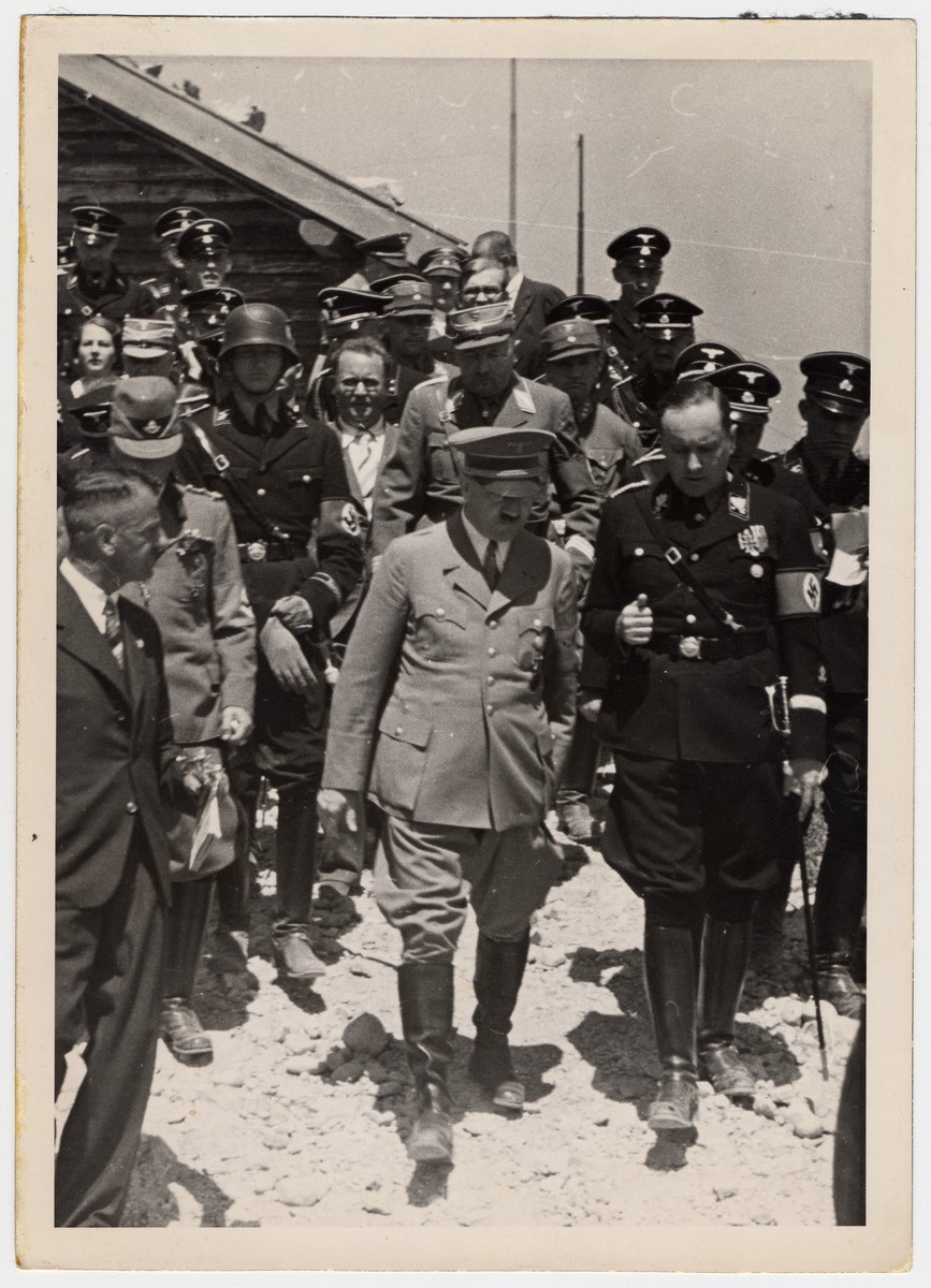 Adolf Hitler (center) walks and converses with other Nazi officials, date unknown. 