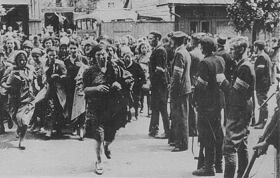 Lithuanian militiamen in Kovno round up Jews during an early pogrom. [LCID: 77608]