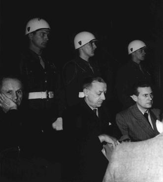 Defendants Karl Doenitz (left), Erich Raeder (center), and Baldur von Schirach under guard in the defendants' dock at Nuremberg. [LCID: 10386]