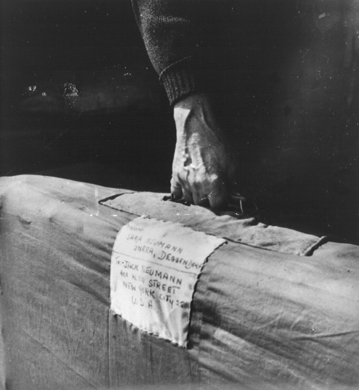 Sara Neumann carries her luggage labled with an address in New York as she leaves the Deggendorf displaced persons camp. [LCID: 62645]