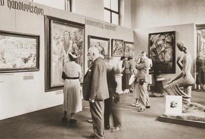 Visitors view the "Degenerate Art" exhibition (Entartete Kunst) at the Munich Hofgarten in July 1937. Works by Lovis Corinth and Franz Marc are visible, among others.