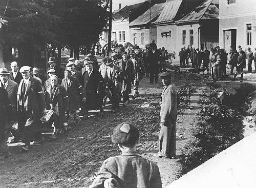 <p>Jews conscripted for forced labor march to a forced-labor camp in Hungary. Hungary, 1940. [Please contact Beth Hatefutsoth for copies of this photograph.]</p>