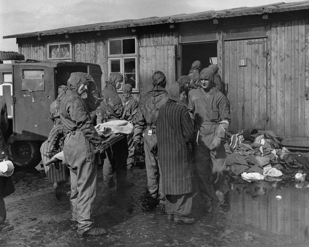 Soon after liberation, British medical officers begin disinfection of camp survivors. [LCID: 75116]