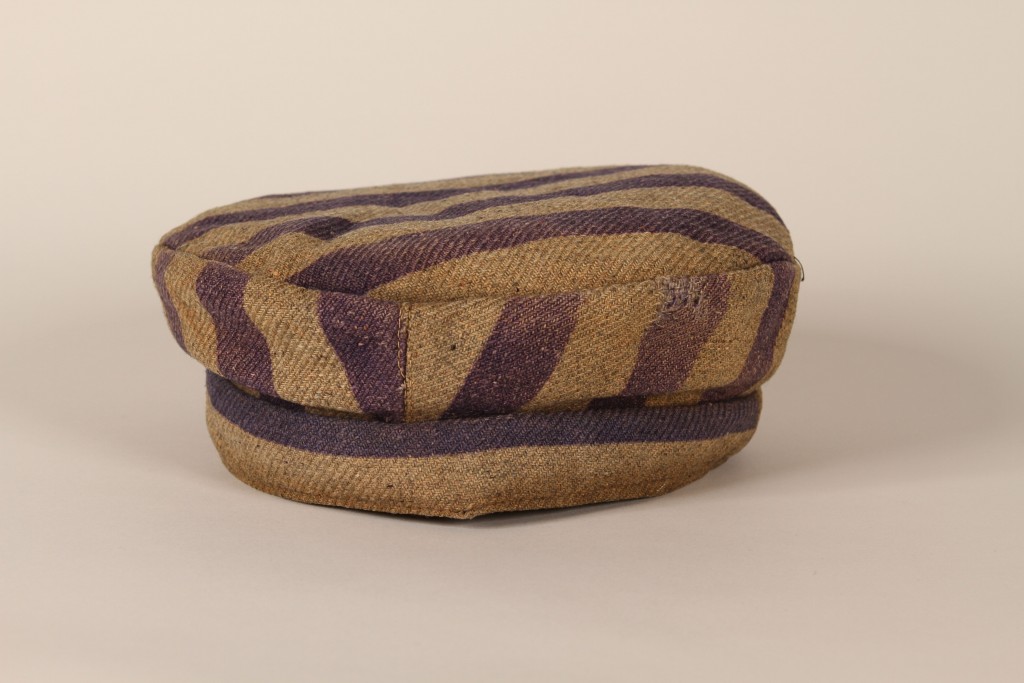 Round cap with small brim made of grey and blue striped uniform fabric.