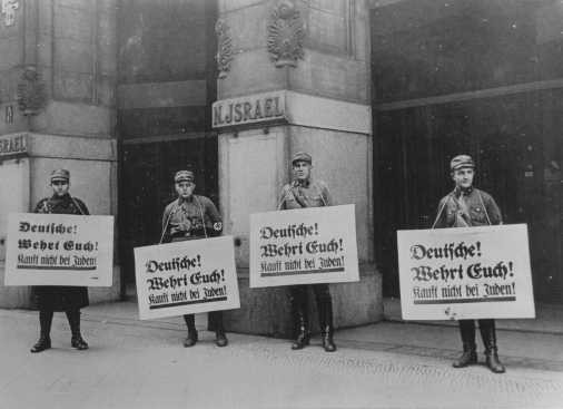 SA men in front of Jewish-owned store urge a boycott with the signs reading "Germans!
