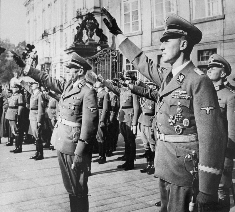 <p><a href="/narrative/10812">Reinhard Heydrich</a> (right) and his deputy, Karl Hermann Frank (center), stand at attention during Heydrich's inauguration as governor of the Protectorate of <a href="/narrative/10723">Bohemia and Moravia</a>. Prague, September 1941.</p>