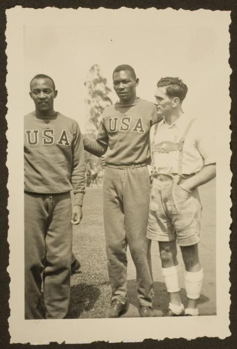 Jesse Owens and Dave Albritton, both American athletes competing in the 1936 Olympics, pose with a German citizen
