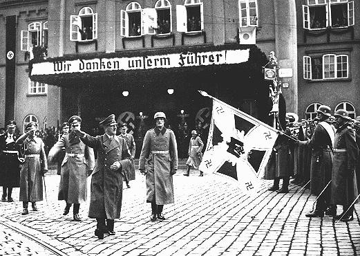 <p>Adolf Hitler in Brno shortly after German troops occupied <a href="/narrative/7295">Czechoslovakia</a>. The sign reads, "We thank our Führer." Brno, Czechoslovakia, March 17, 1939.</p>