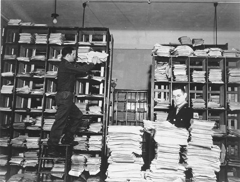 US Army staffers organizing stacks of German documents collected by war crimes investigators as evidence for the International Military Tribunal.