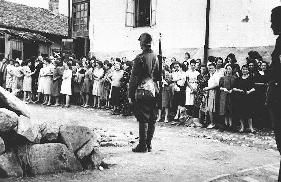  In the Kishinev ghetto, Jewish women guarded by Romanian soldiers are rounded up for forced labor. [LCID: 43186b]