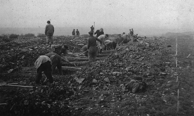 German civilians conscripted from nearby towns dig graves for some of the victims of the Ohrdruf camp.