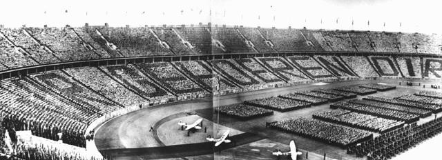 At a ceremony during the 1936 Olympic Games, German spectators spell out the phrase, directed at Adolf Hitler, "Wir gehoeren Dir" [We belong to you].