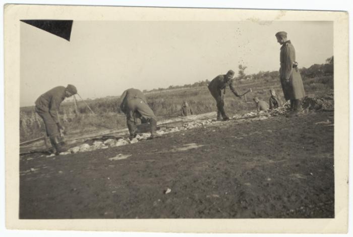 German soldiers force Soviet prisoners of war to construct a rail line. Place uncertain, 1941-1942.
 
This photograph is from an album discovered in a search mission in an abandonend building near Nuremberg by Steven Imburgia while serving with the 633rd Anti-Aircraft Unit.
 