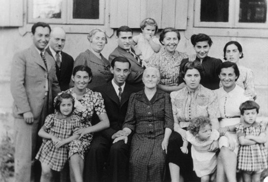 Three generations of a Jewish family pose for a group photograph.