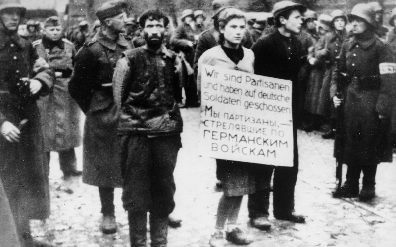 German soldiers parade three young people through Minsk before their execution.