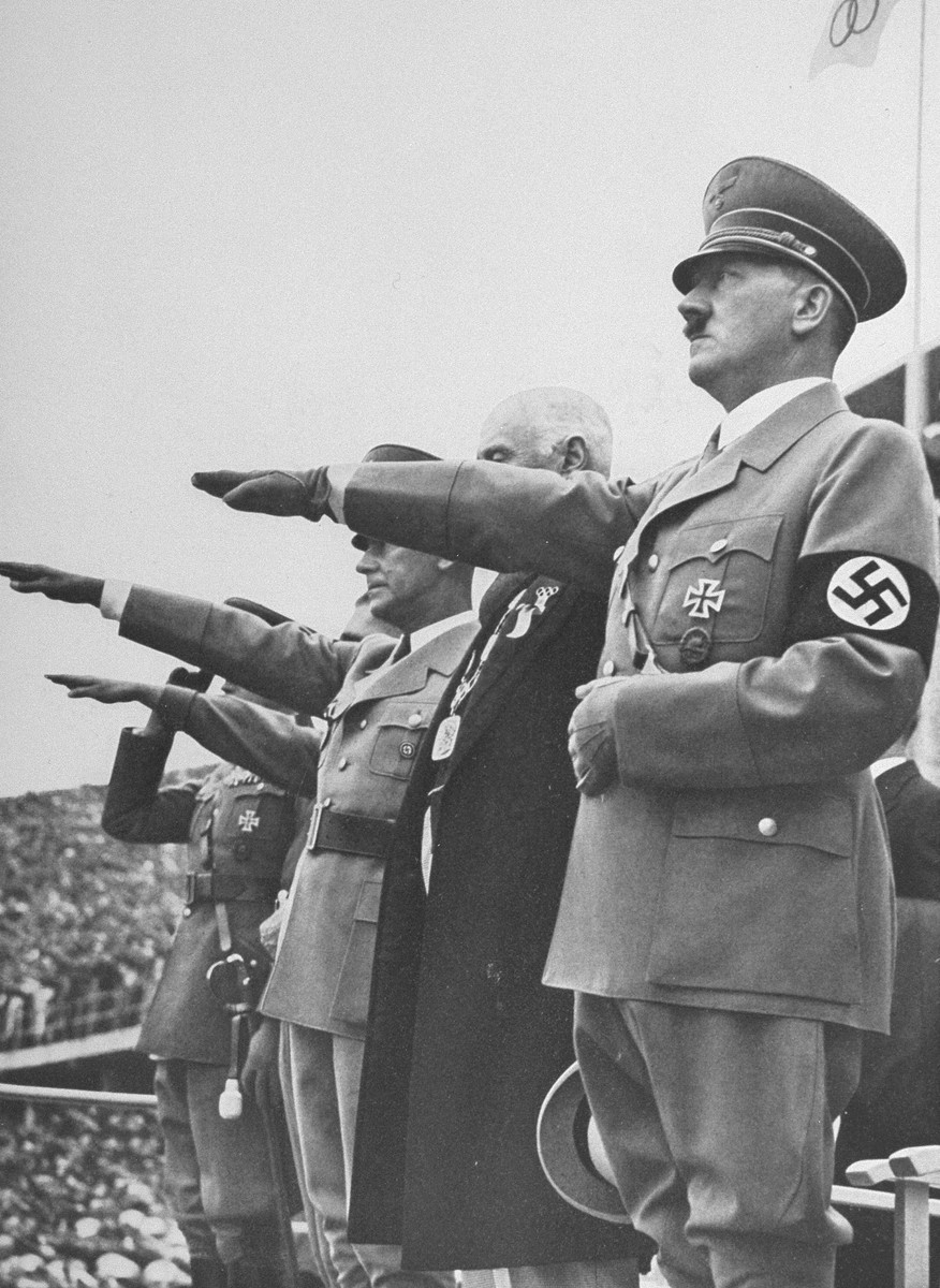 Adolf Hitler salutes the Olympic flag at the opening of the Olympic Games in Berlin. [LCID: 73495]