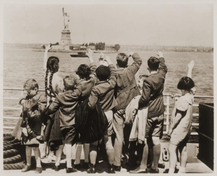 Jewish refugee children wave at the Statue of Liberty as the President Harding steams into New York harbor.