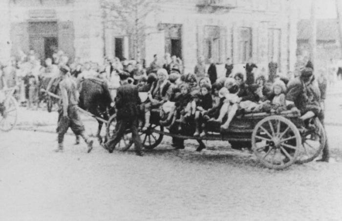 Jewish women and children are transported by horse-drawn wagon during a deportation action in the Siedlce ghetto