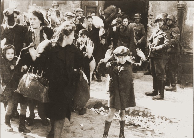 Jews captured by German troops during the Warsaw ghetto uprising in April–May 1943. This photograph appeared in the Stroop Report, an album compiled by SS Major General Juergen Stroop, commander of German forces that suppressed the Warsaw ghetto uprising. The album was introduced as evidence at the International Military Tribunal at Nuremberg. In the decades since the trial this photo has become one of the iconographic images of the Holocaust.