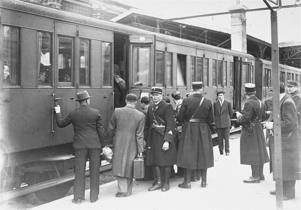 Jewish deportees, guarded by French police, board a train at the Austerlitz station for transport to the Pithiviers internment camp. [LCID: 44279]
