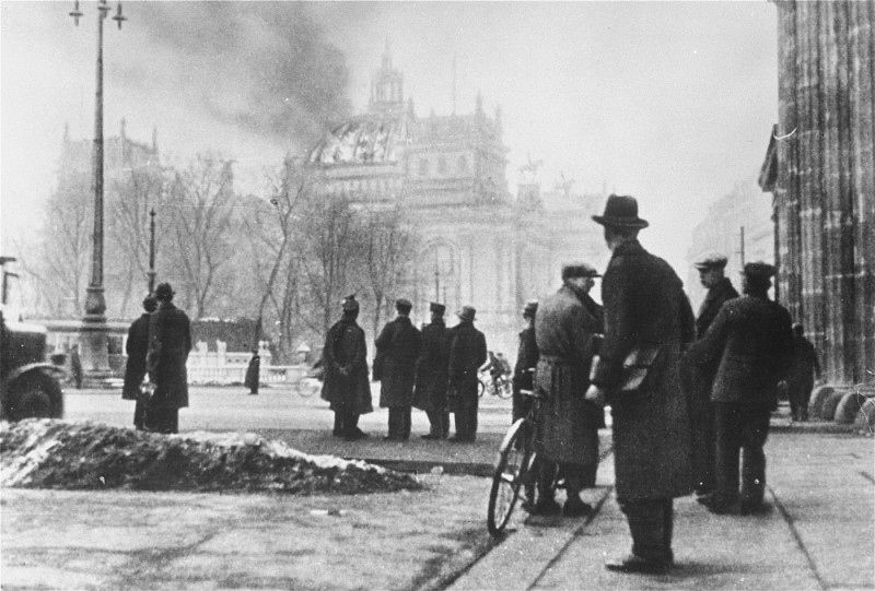 Onlookers in front of the Reichstag (German parliament) building the day after it was damaged by fire. On this same day, the Nazis implemented the Decree of the Reich President for the Protection of the People and the State. It was one of a series of key decrees, legislative acts, and case law in the gradual process by which the Nazi leadership moved Germany from a democracy to a dictatorship. Berlin, Germany, February 28, 1933.