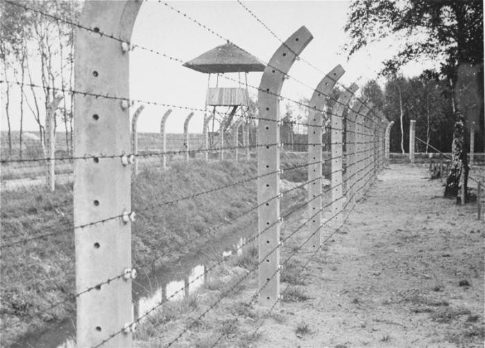 View of the barbed wire fence and a watch tower at Vught after the liberation of the camp.