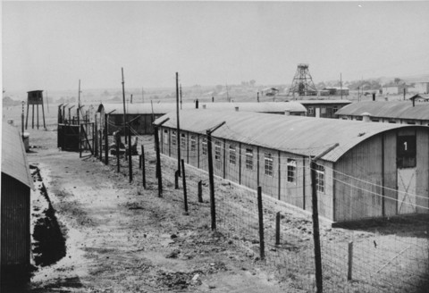  A view of the Trzebinia labor camp, a subcamp of Auschwitz, showing a watchtower, the main gate, the barbed-wire fence, and several ... [LCID: 51035]