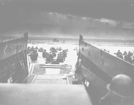 US troops wade ashore at Normandy on D-Day, the beginning of the Allied invasion of France to establish a second front against German forces in Europe.