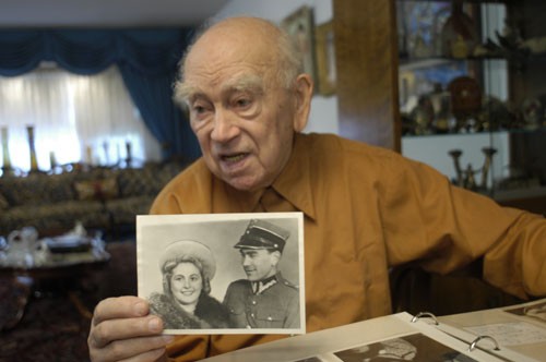 Norman Salsitz holds a photograph of himself and Amalie. [LCID: athns244]