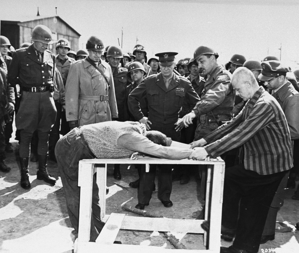 A survivor shows US Generals Eisenhower, Patton, and Bradley how inmates at Ohrdruf camp were tortured. [LCID: 63511]