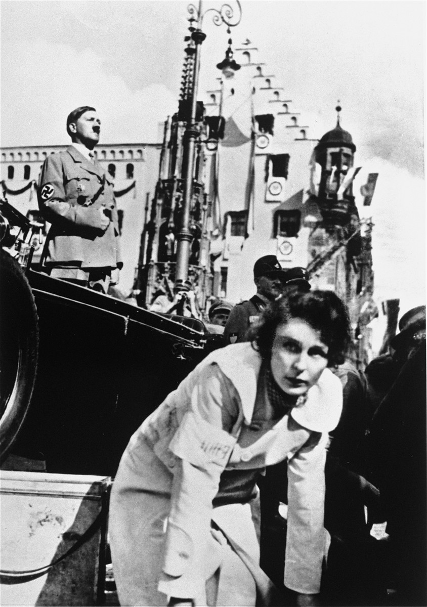 Leni Riefenstahl, with Adolf Hitler in the background, directs the shooting of a film about the Reich Party Day.