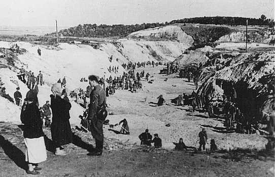 Un membre d’un Einsatzgruppe (unité mobile d'extermination) parle avec deux femmes non identifiées au sommet du ravin de Babi ... [LCID: 83712]