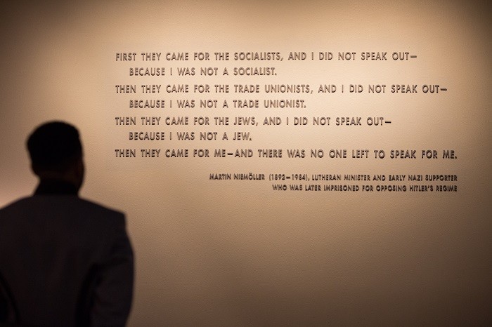 A visitor stands in front of the quotation from Martin Niemöller that is on display in the Permanent Exhibition of the United States Holocaust Memorial Museum.