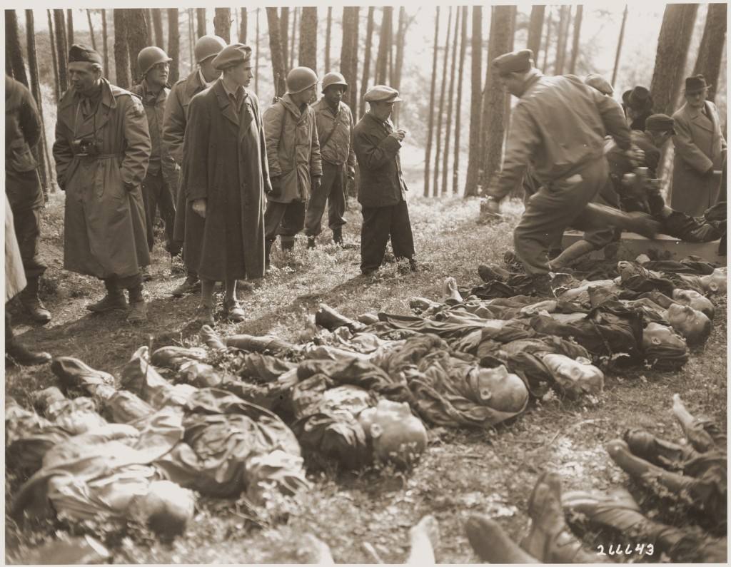A Hungarian Jewish youth views the body of his father, who was shot by the SS during a death march, while American liberators prepare ... [LCID: 82958]